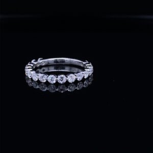 Diamond eternity ring reflecting on black surface
