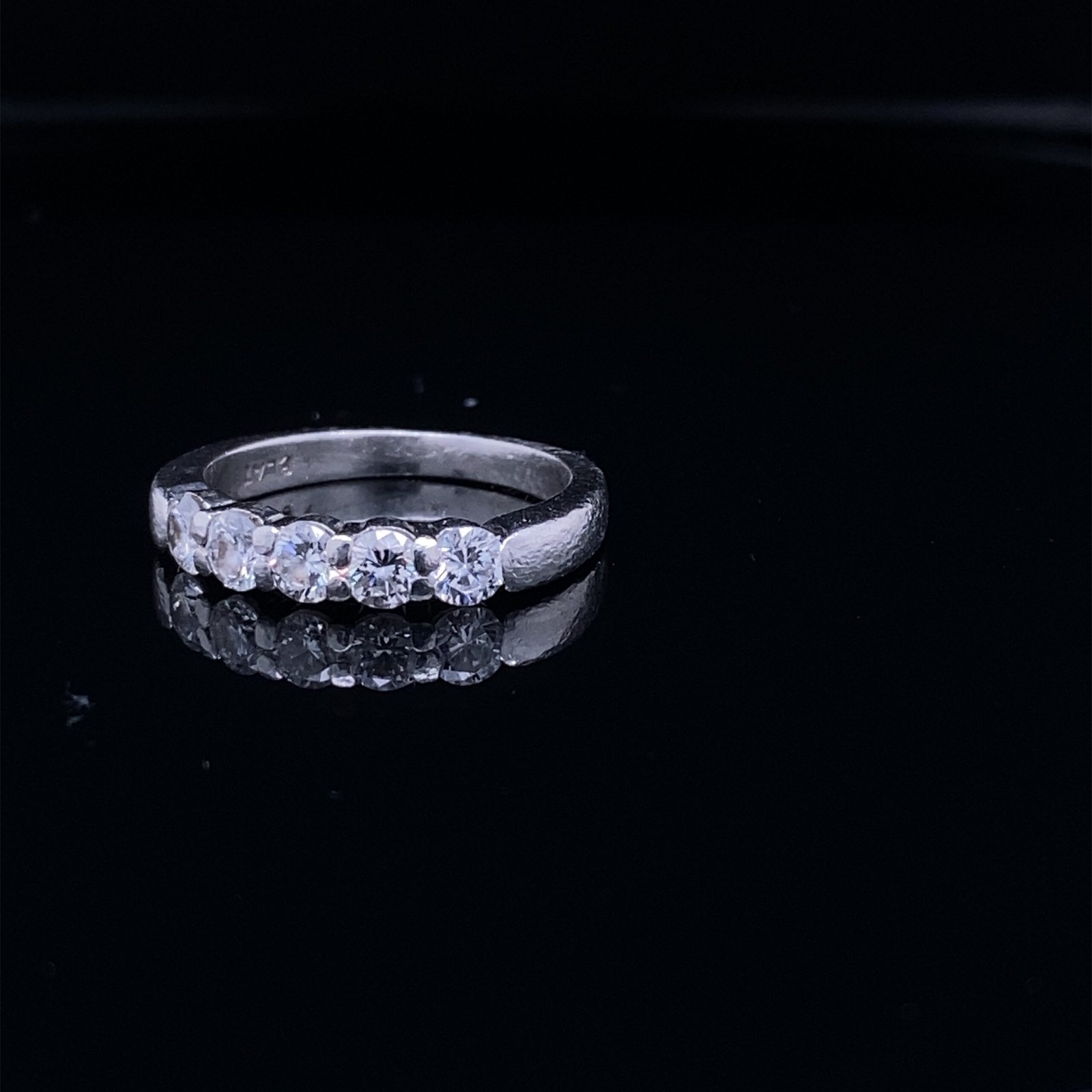 Five diamond engagement ring on black surface