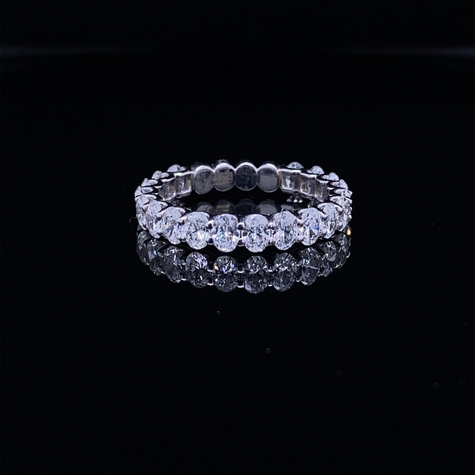Diamond eternity band on black reflective surface