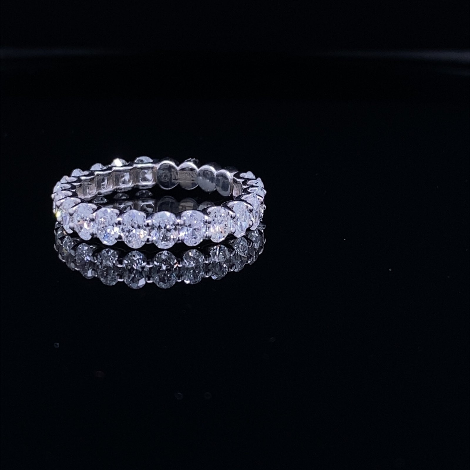 Diamond eternity ring on black reflective surface